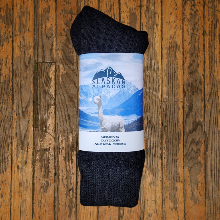 Pair of charcoal gray Alaskan Alpaca socks wrapped in a label with an alpaca and mountains.