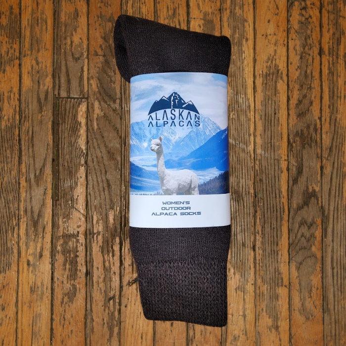 Pair of brown alpaca socks with a label showing an alpaca in a mountain scene.