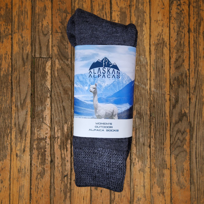 Gray alpaca socks with a label showing an alpaca and mountains.