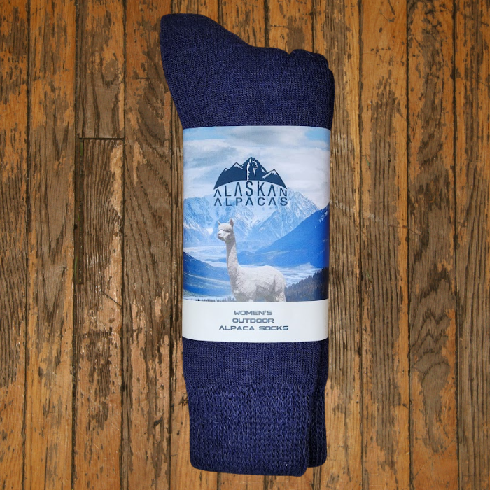 Pair of dark blue alpaca socks with a label featuring an alpaca and mountains.