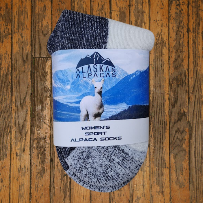 Alpaca socks with a blue and white label on a wooden surface.