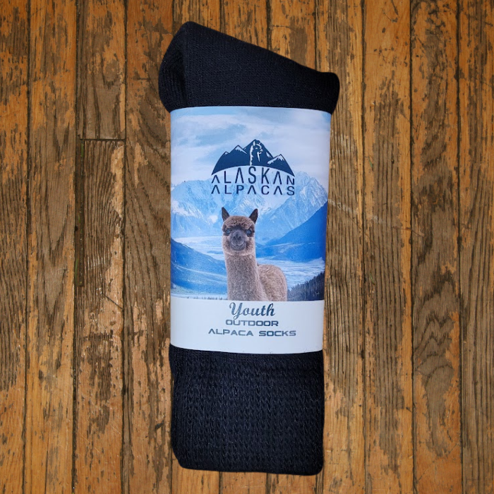Dark gray Youth Alpaca socks rolled up, with label showing an alpaca in a mountain scene.