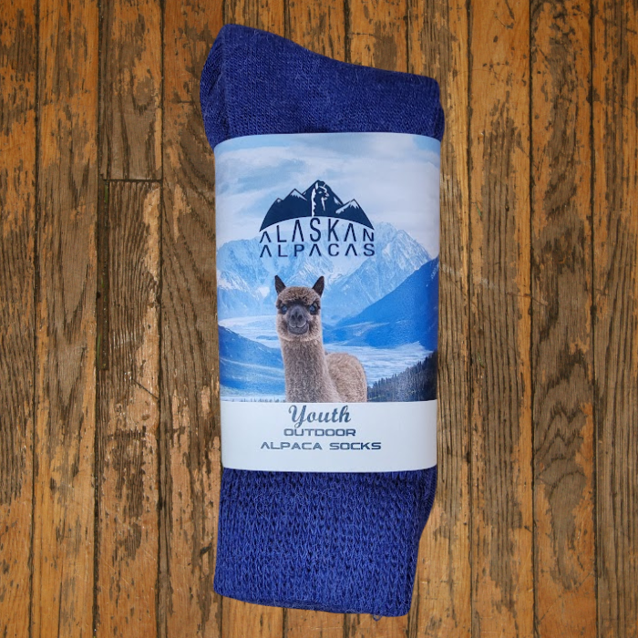 Blue alpaca wool socks with a label showing an alpaca in a snowy mountain landscape.