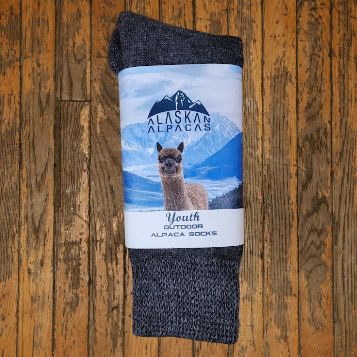 Alpaca socks with a label that features a mountain scene and an alpaca.