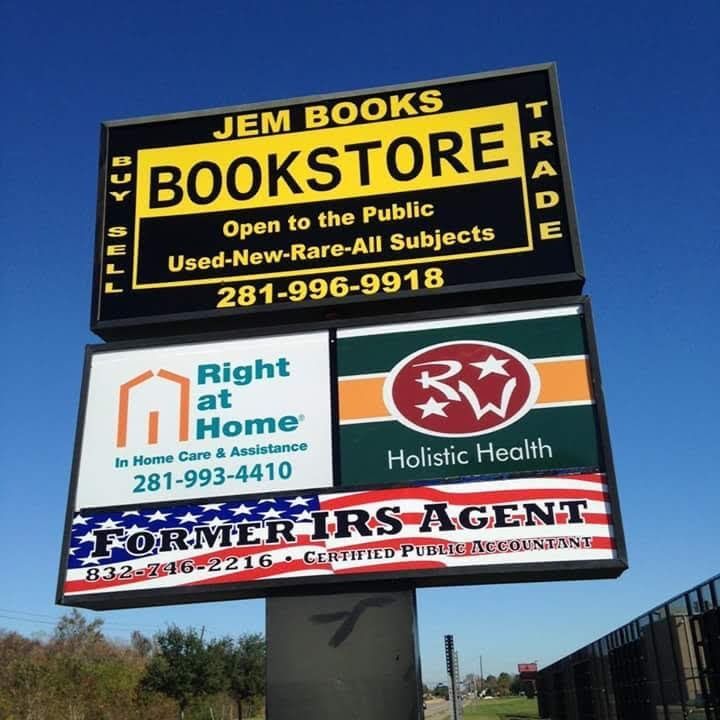 A technician wearing gloves applies a vinyl graphic decal to the side of a white commercial van.