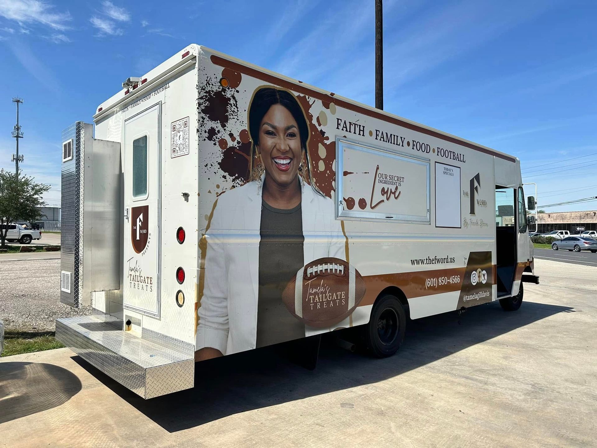 A row of branded Cook Children's delivery vans in blue, red, and white parked on a city street near office buildings.