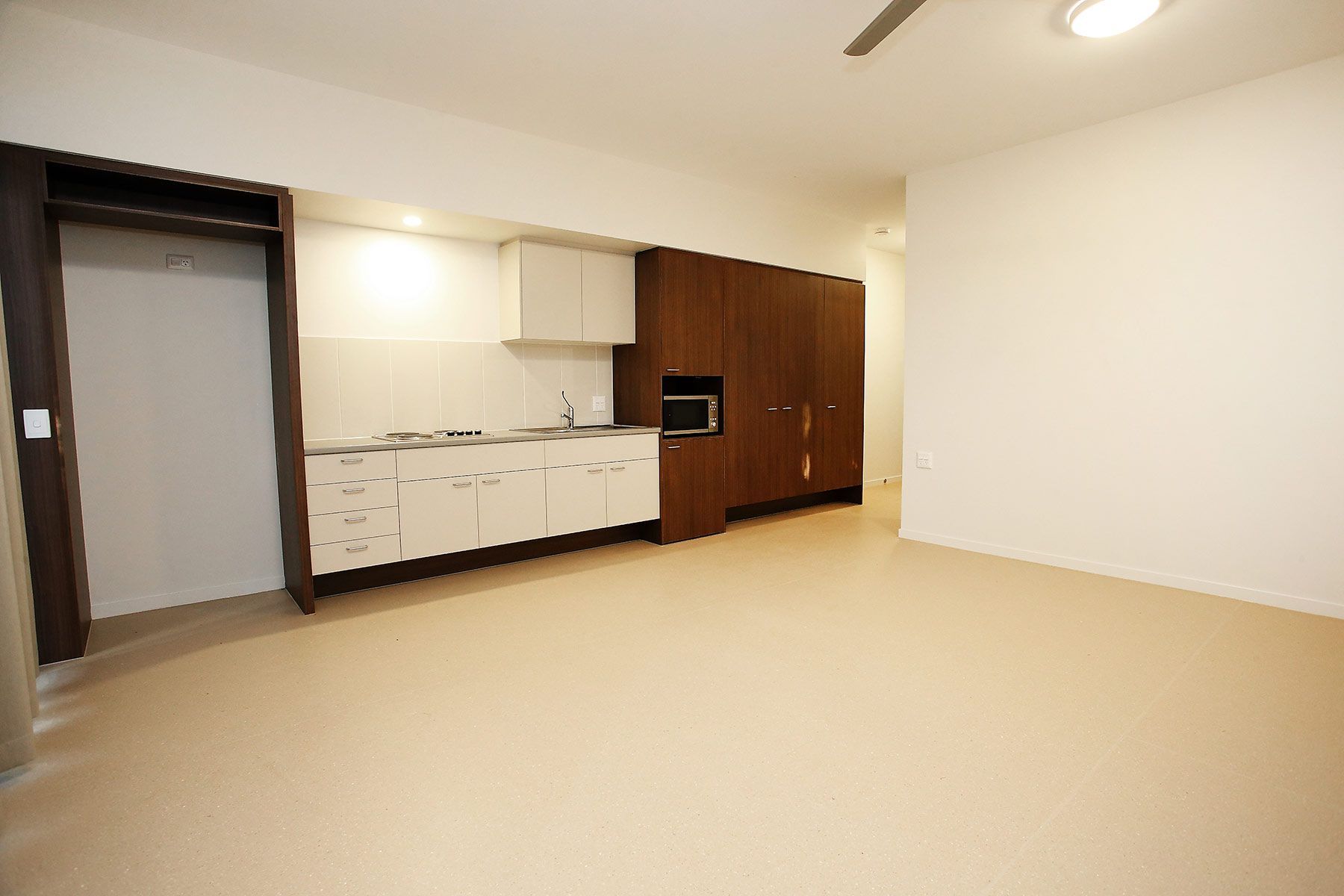 Kitchen in a Spacious Room With Wooden Cabinet With a Microwave — Nick Favot Painting In Bohle, QLD