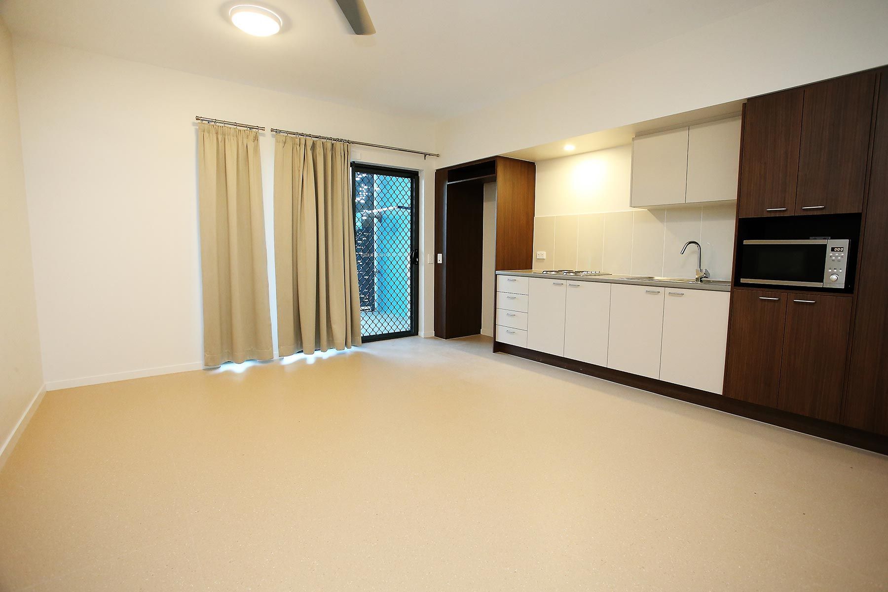 Kitchen With White and Brown Cabinets and a Microwave — Nick Favot Painting In Bohle, QLD
