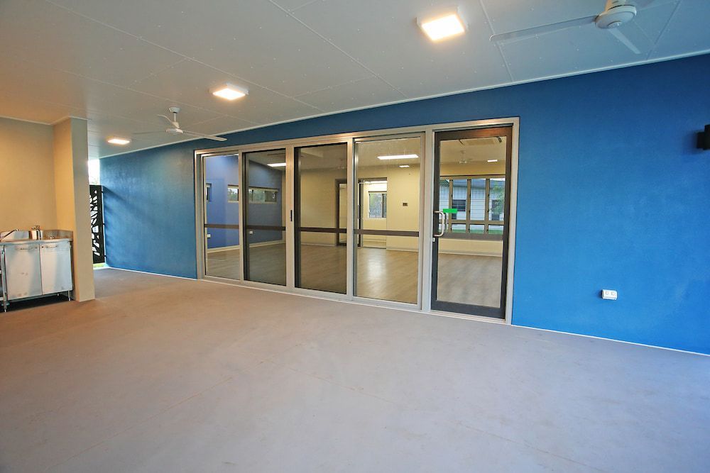 An Empty Room With Blue Walls and Sliding Glass Doors — Nick Favot Painting in Bohle, QLD