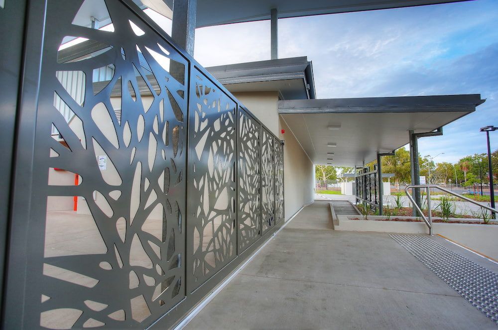A Fence With a Geometric Design on It is Next to a Building — Nick Favot Painting in Bohle, QLD