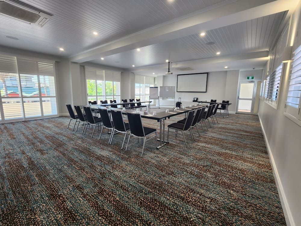 A Large Conference Room With Tables and Chairs and a Large Screen — Nick Favot Painting in Bohle, QLD