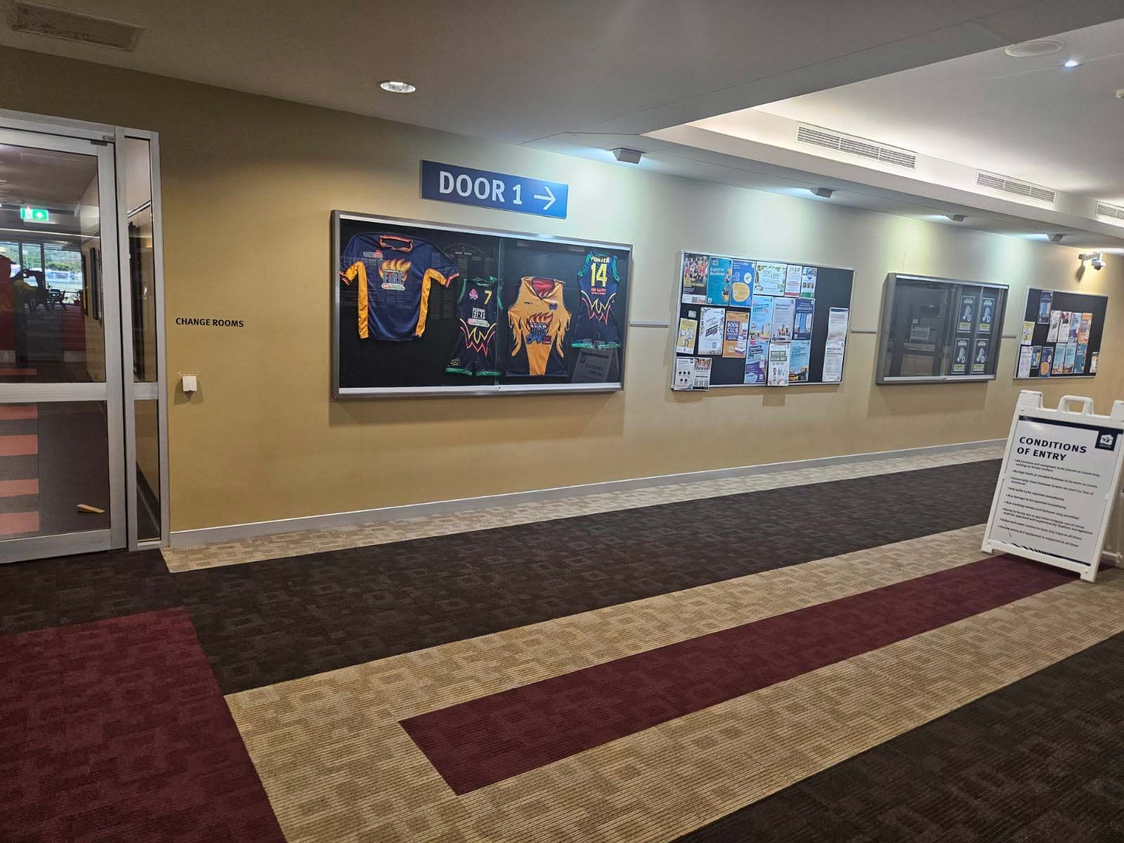 Hallway With Sports Jerseys in Glass Display — Nick Favot Painting In Bohle, QLD