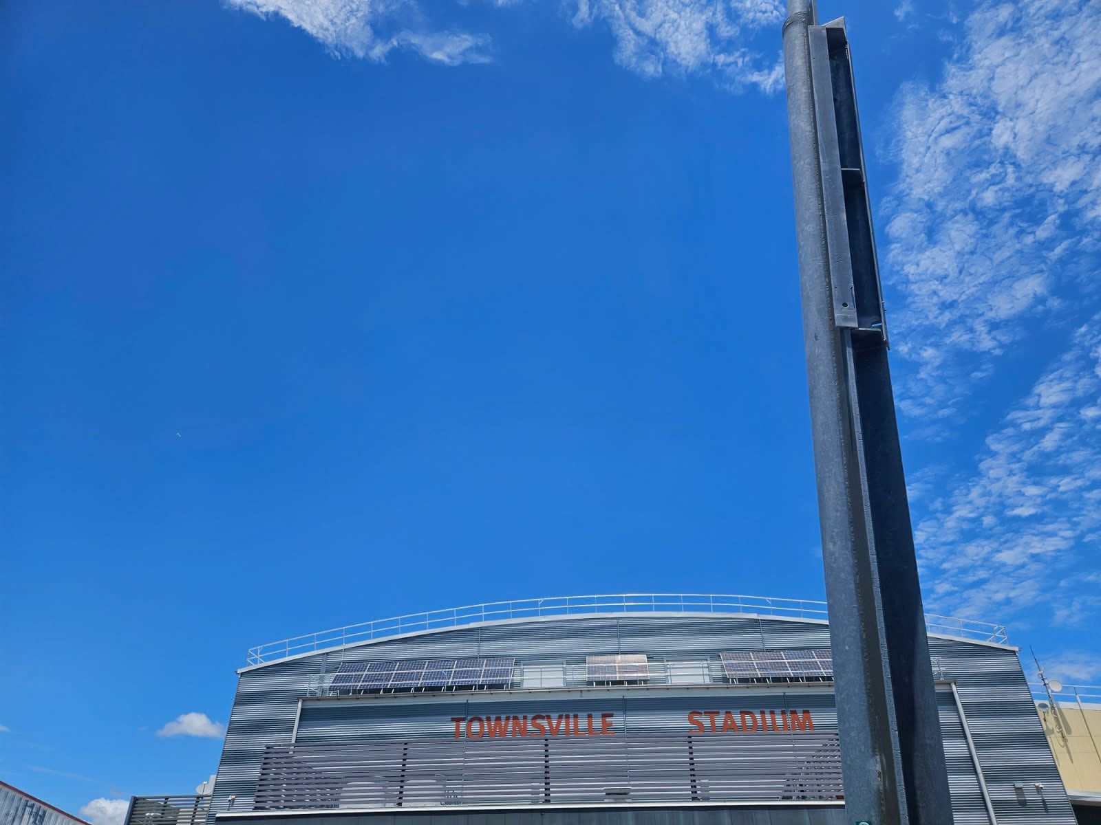 Gray Stadium Exterior With a  Label and a Tall Light Pole — Nick Favot Painting In Bohle, QLD