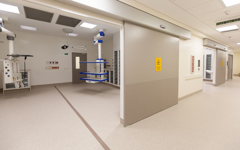 A Hospital Hallway With Sliding Doors and a Ceiling Fan — Nick Favot Painting in Bohle, QLD