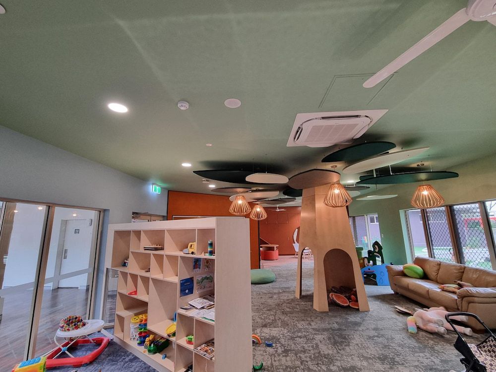 A Living Room With a Couch and a Shelf With Toys on It — Nick Favot Painting in Bohle, QLD