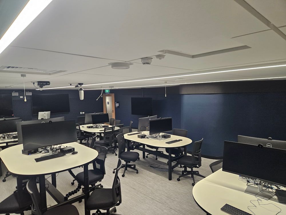 A Large Room With Tables and Chairs Filled With Computers — Nick Favot Painting in Bohle, QLD