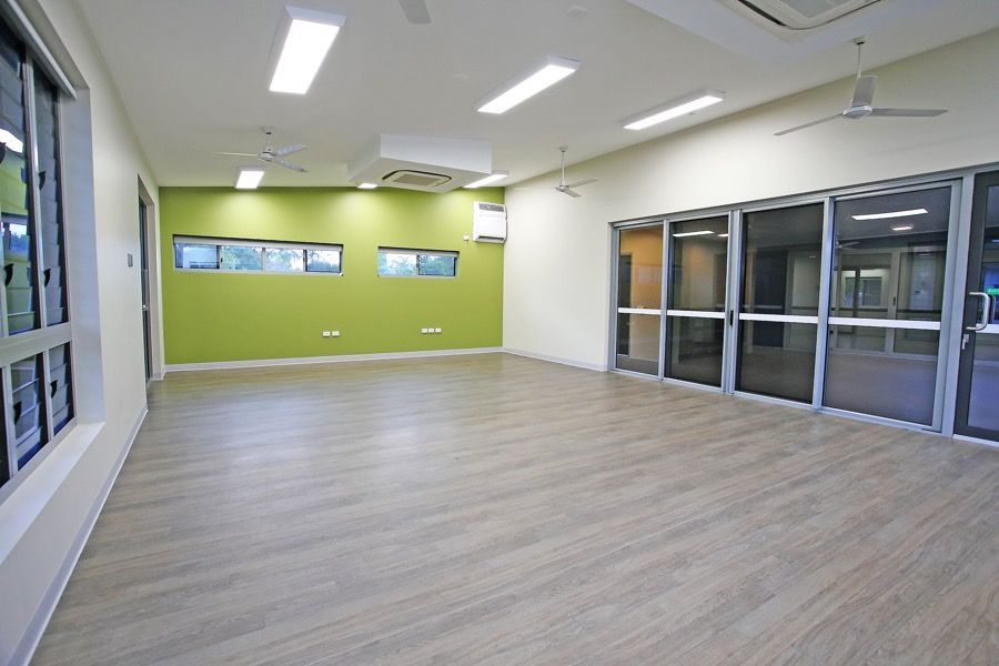 An Empty Room With Wooden Floors and a Green Wall — Nick Favot Painting in Bohle, QLD