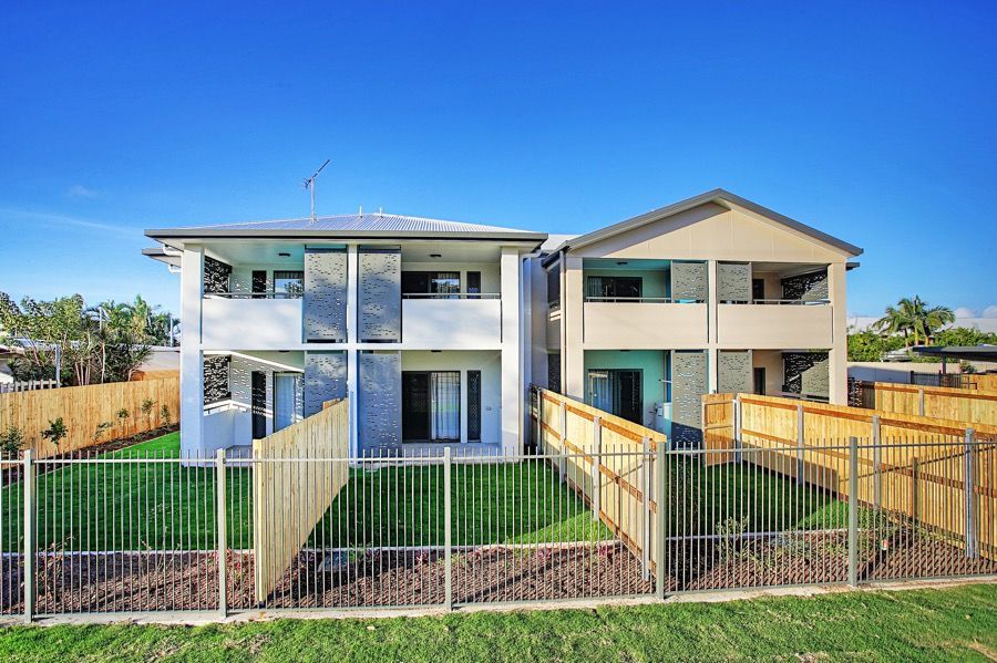 A Large House With a Wooden Fence Around It — Nick Favot Painting in Bohle, QLD