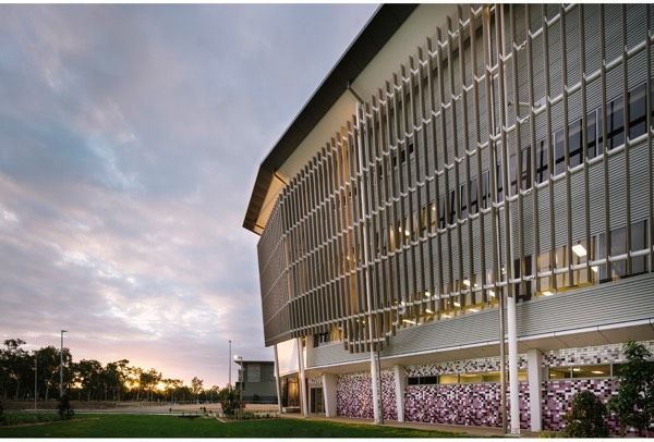 A Large Building With a Lot of Windows is Lit Up at Night — Nick Favot Painting in Bohle, QLD