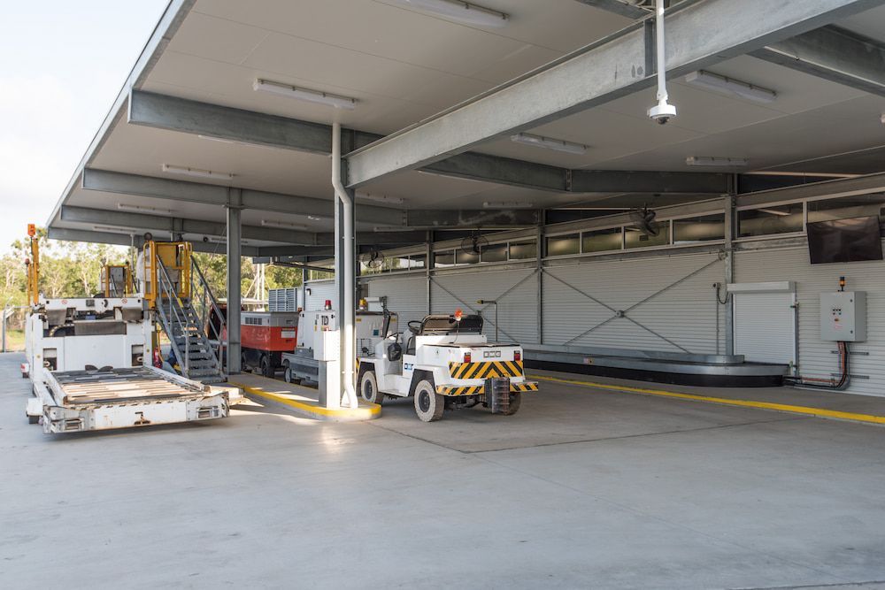 A Warehouse With a Lot of Vehicles Parked Inside of It — Nick Favot Painting in Bohle, QLD