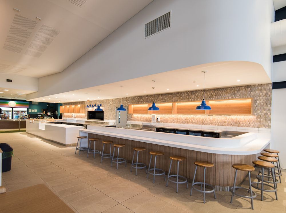 There is a Long Bar With Stools in the Middle of the Room — Nick Favot Painting in Bohle, QLD