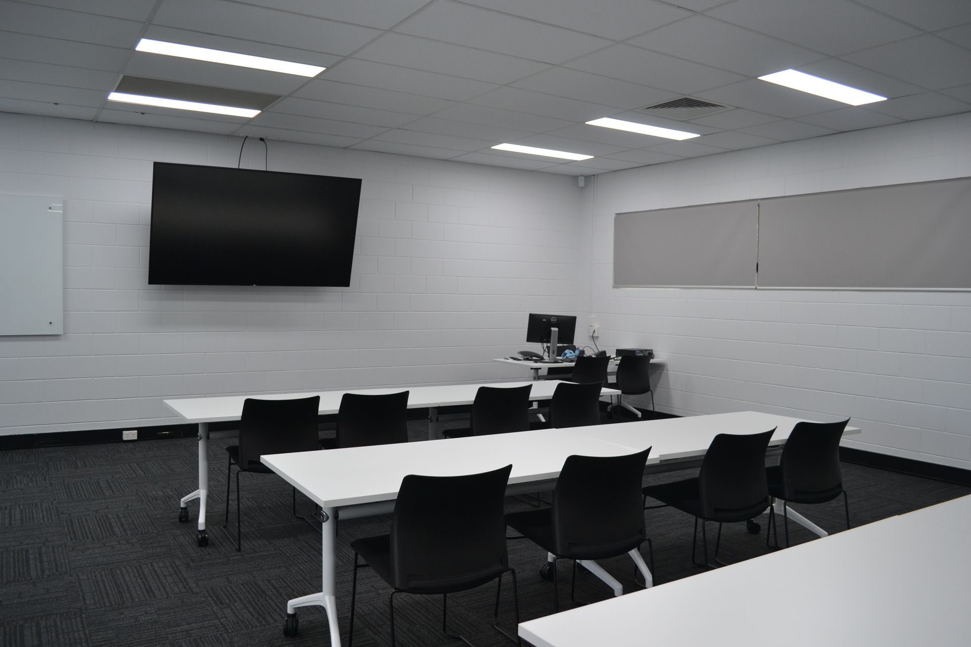 A Modern Room With Tables, Chairs, and a Large Wall-mounted TV — Nick Favot Painting In Bohle, QLD