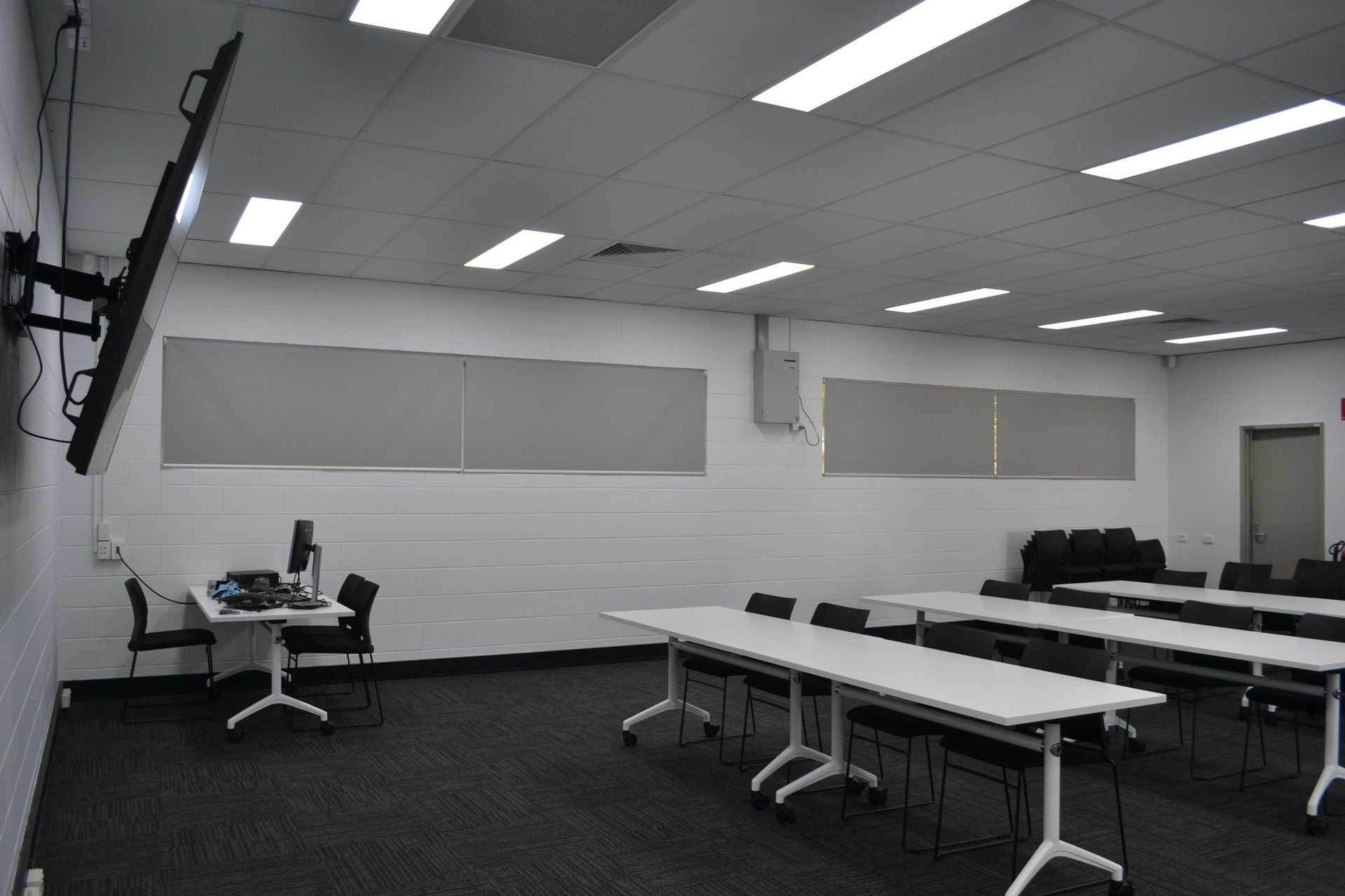 Room With White Tables, Black Chairs, and a Wall-mounted Screen — Nick Favot Painting In Bohle, QLD