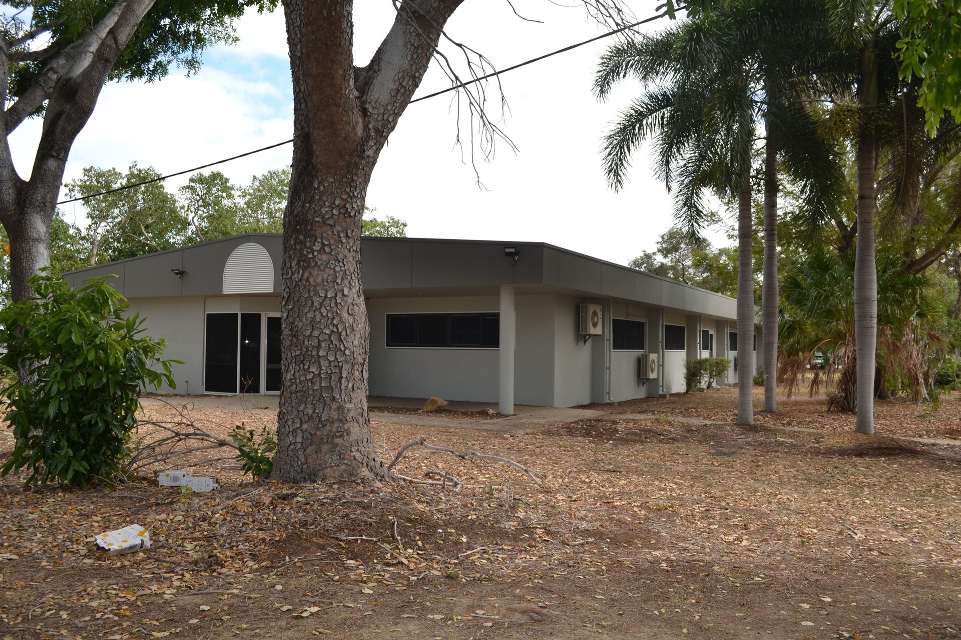 Grey Building With Large Windows and Air Conditioning Units — Nick Favot Painting In Bohle, QLD