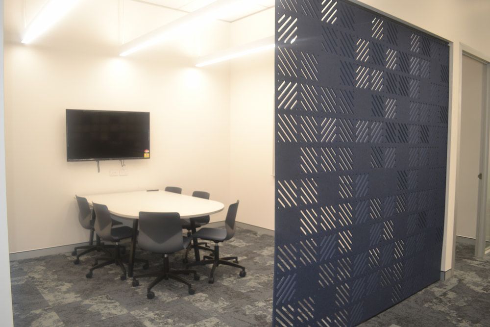 A Conference Room With a Round Table and Chairs and a Flat Screen Tv — Nick Favot Painting in Bohle, QLD