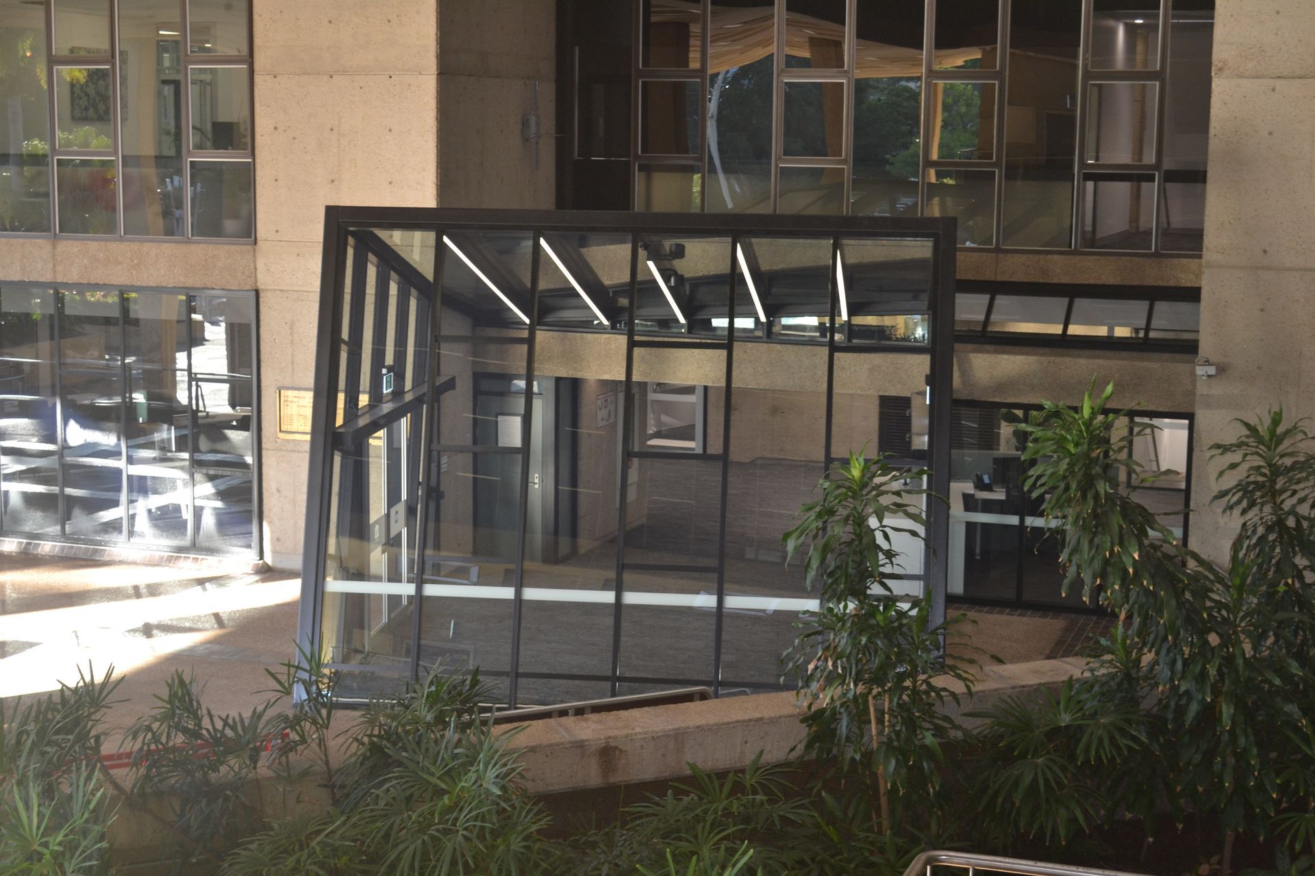 Modern Interior With Large Slanted Glass Windows Reflecting Sunlight — Nick Favot Painting In Bohle, QLD