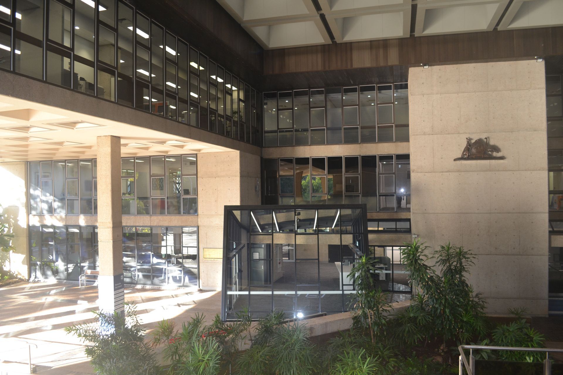 A Modern Building With Large Glass Windows and Green Plants — Nick Favot Painting In Bohle, QLD