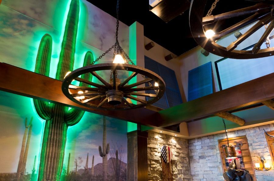 A Wagon Wheel is Hanging From the Ceiling in a Room With a Cactus on the Wall — Nick Favot Painting in Bohle, QLD