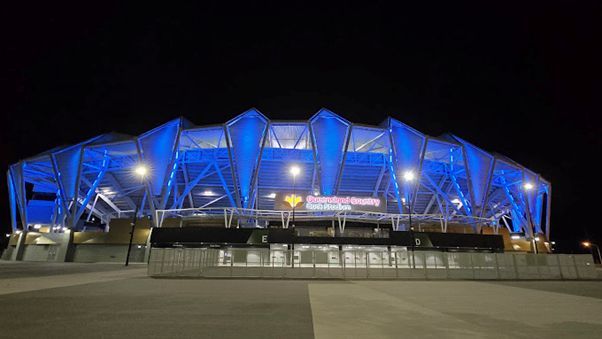 A Large Stadium is Lit Up With Blue Lights at Night — Nick Favot Painting In Bohle, QLD