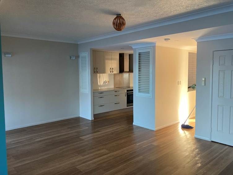 An Empty Room With Wooden Floors and White Walls — Nick Favot Painting in Bohle, QLD