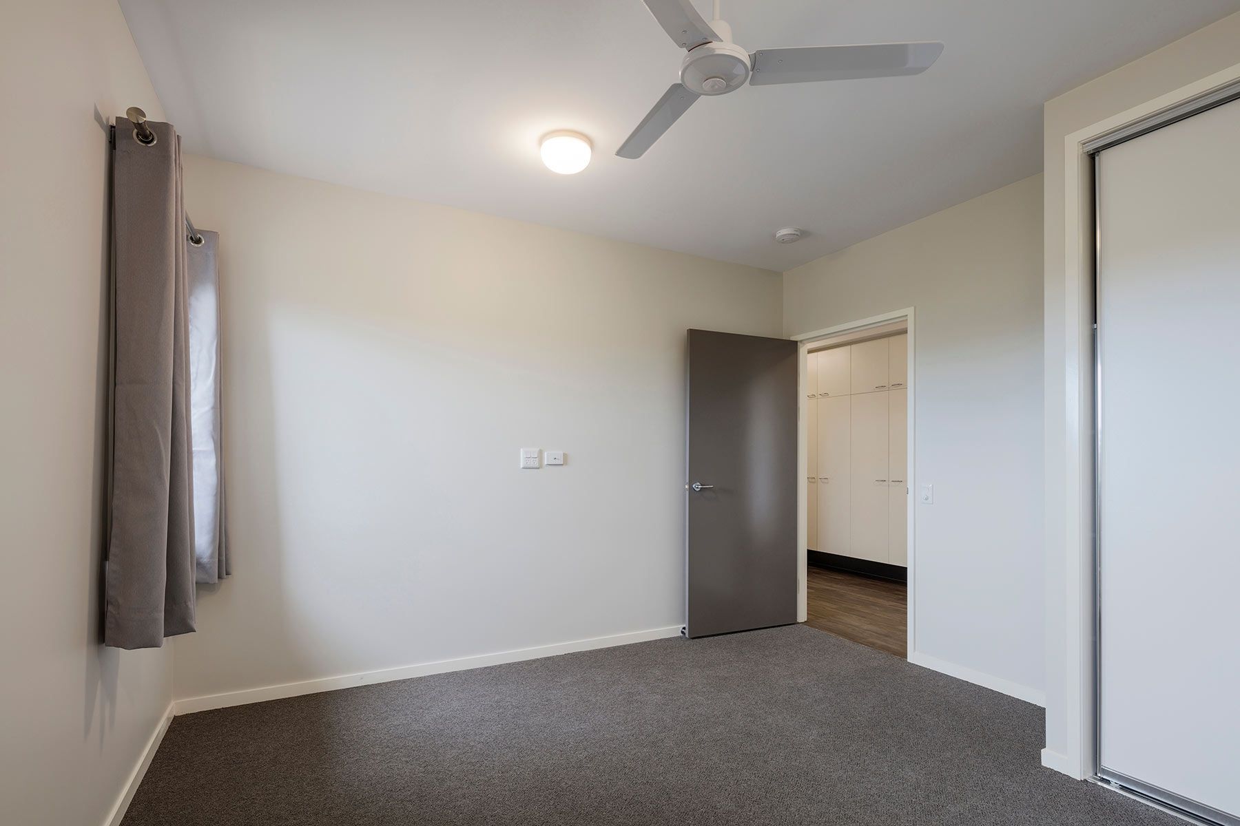 A Bedroom With a Ceiling Fan and a Door — Nick Favot Painting In Bohle, QLD