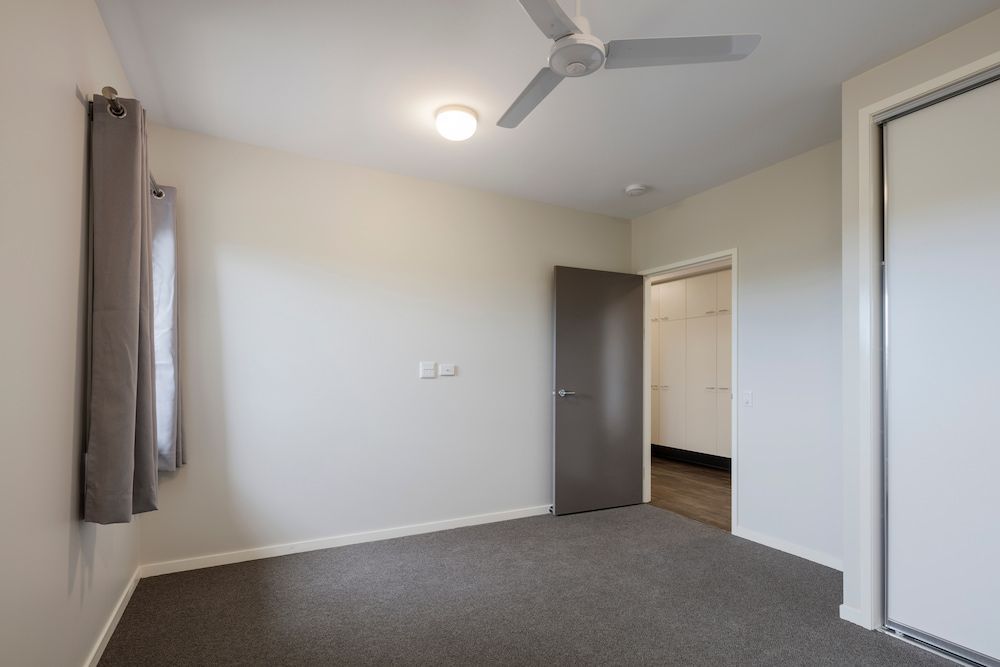 An Empty Bedroom With a Ceiling Fan and a Door — Nick Favot Painting in Bohle, QLD