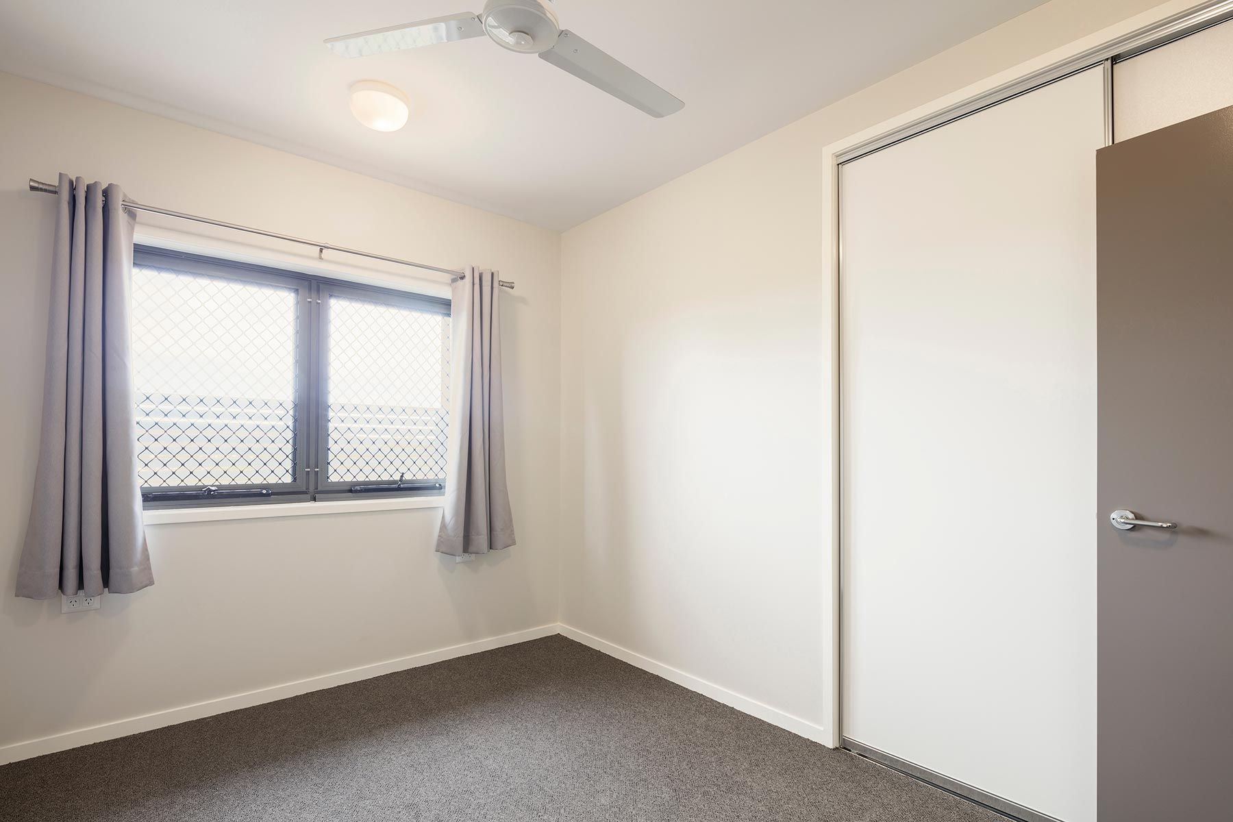 A Room With Beige Walls, Grey Carpet, and a Ceiling Fan — Nick Favot Painting In Bohle, QLD