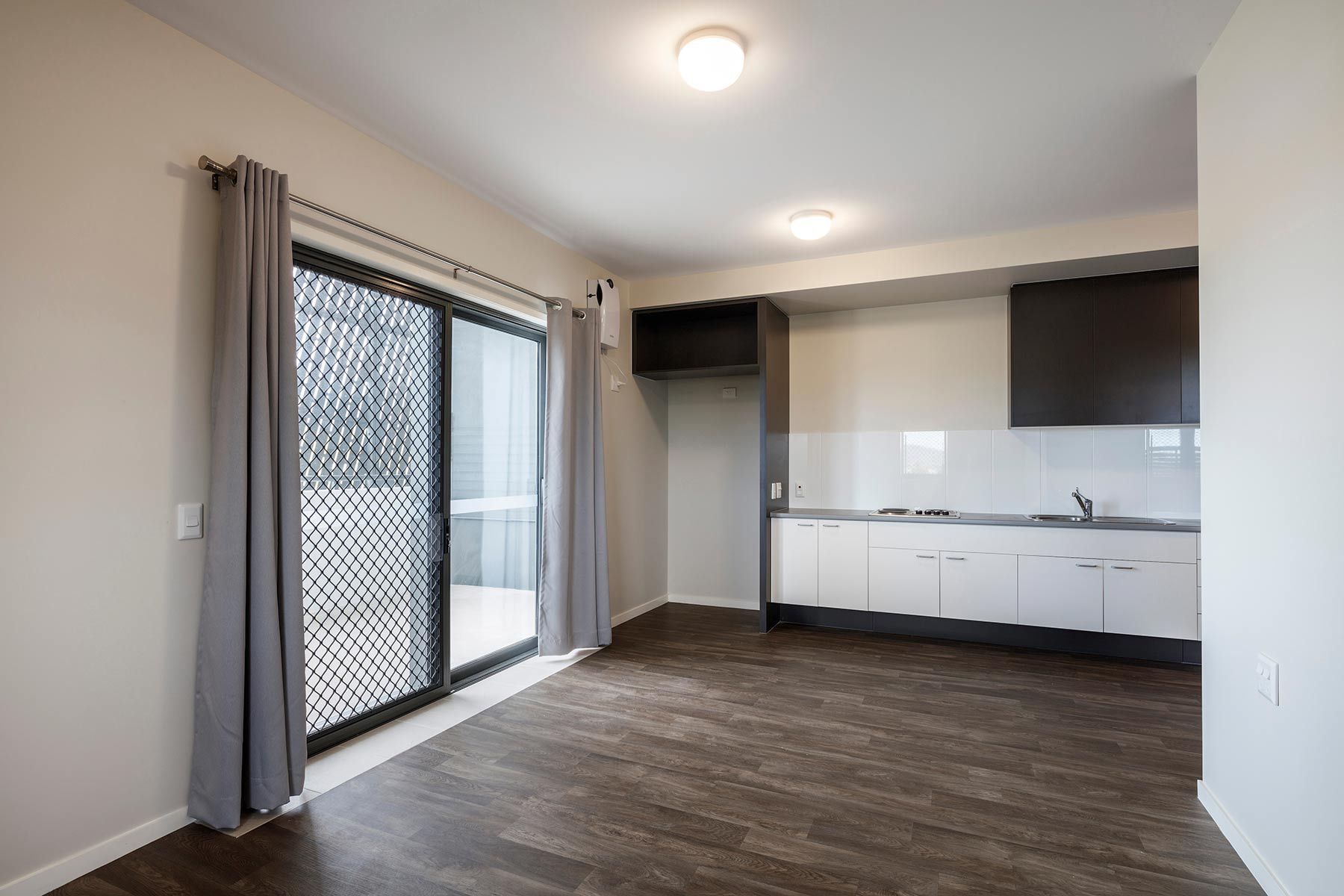 Kitchen With Dark Wood Floor and Sliding Glass Door — Nick Favot Painting In Bohle, QLD
