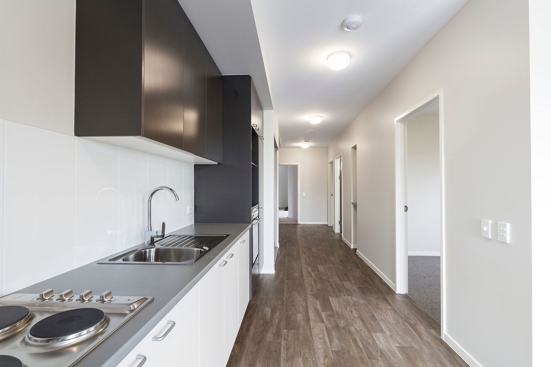 Kitchen and Hallway With Sleek Black and White Cabinets — Nick Favot Painting In Bohle, QLD