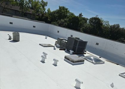 A white roof with a lot of vents on it.