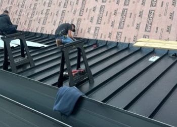 A man is working on the roof of a building.