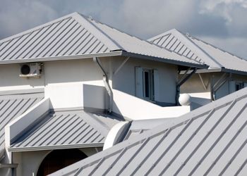 A white house with a metal roof and a window