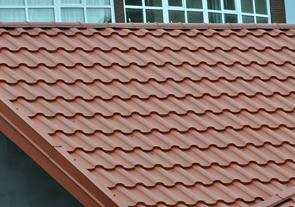 A close up of a roof with a window in the background