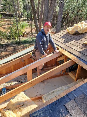 A man is working on the roof of a house.