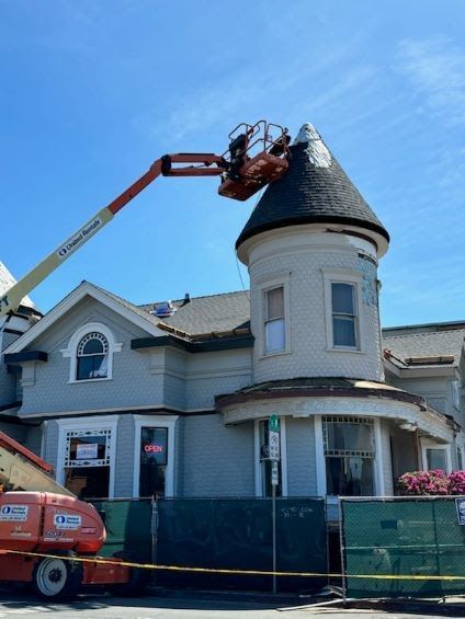 A jlg crane is working on the roof of a house