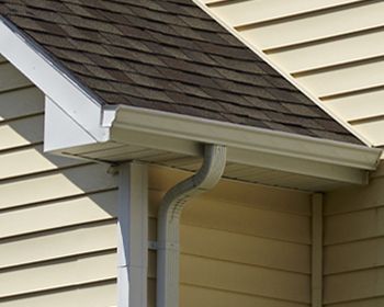 A close up of a gutter on the side of a house.
