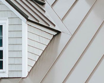 A close up of a house with a roof and a window.