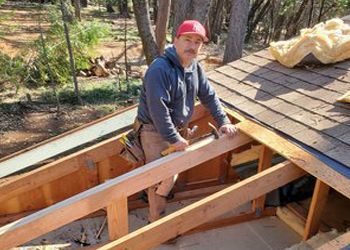 A man is standing on top of a wooden structure.