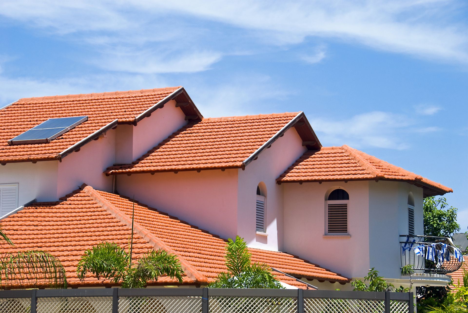 A house with a red tiled roof and a balcony