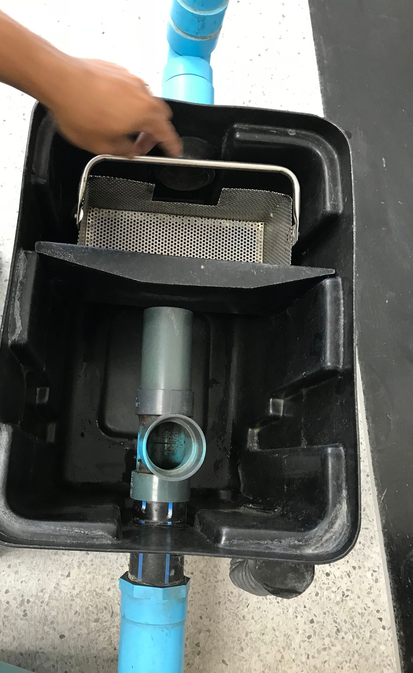 A person is cleaning a grease trap.